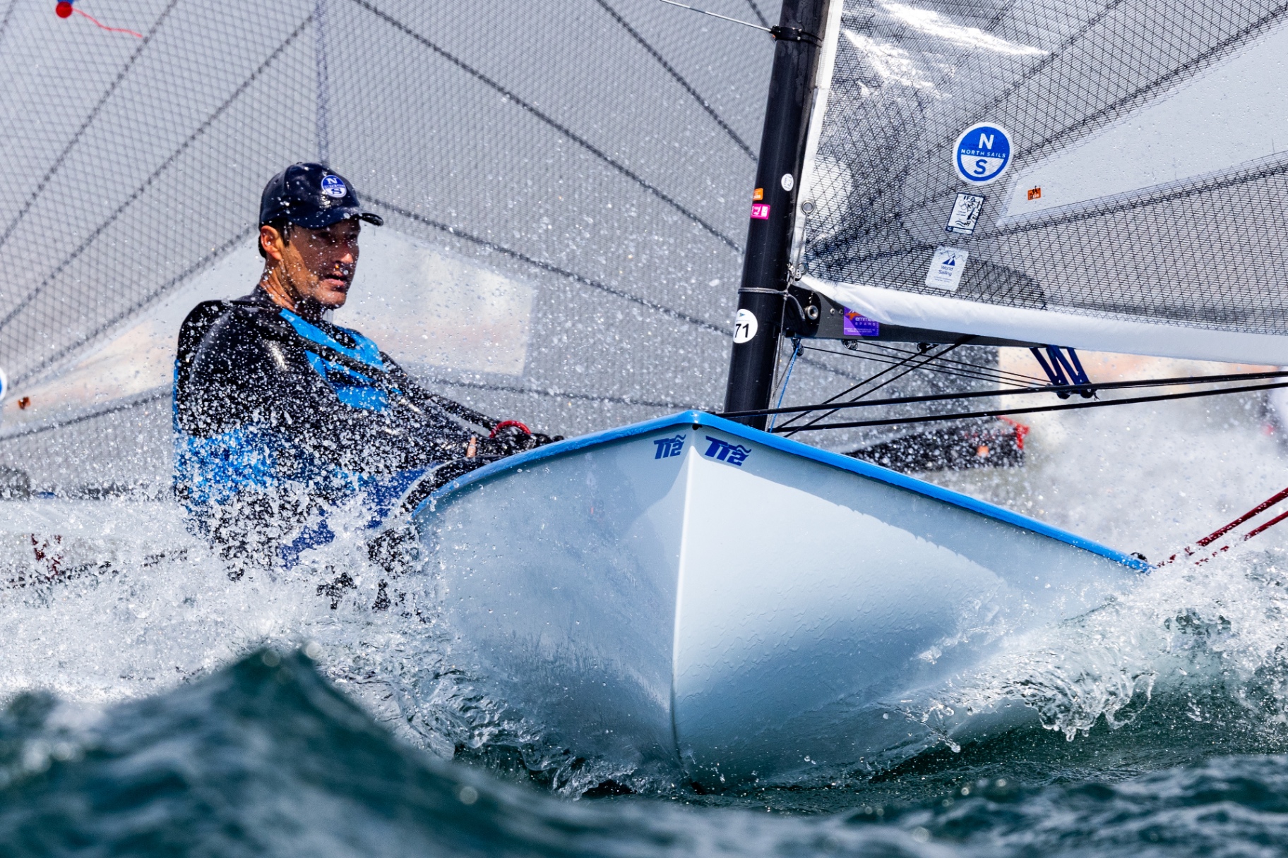 Finn dinghy racing through ocean waves